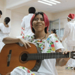Ana Juana Bautista Escamilla smiling with a guitar at a Christmas recital.